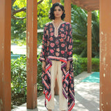 Woman wearing a floral dress with a long jacket in an outdoor setting