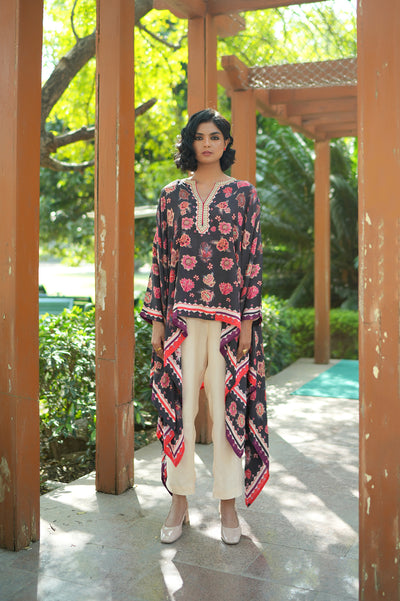 Woman wearing a floral dress with a long jacket in an outdoor setting